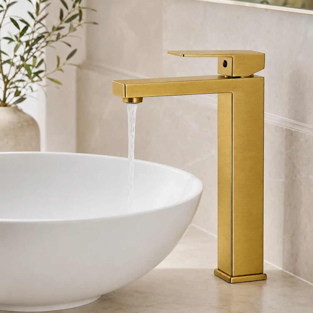 Grifería alta Paris oro cepillado en uso con agua cayendo dentro de un lavamanos