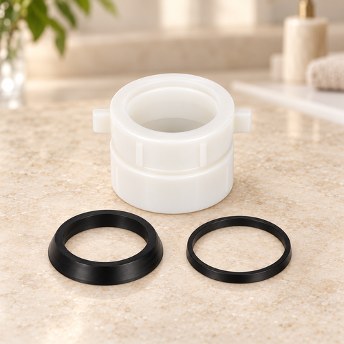 Adaptador para sifón en P de 1½″ o 1¼″ suelto sobre piedra cálida antes de instalar; accesorios del ambiente no incluidos.
