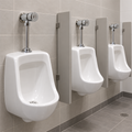 Llave push para orinal instalada en baño institucional