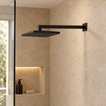 Brazo de ducha cuadrado negro instalado en pared con escudo; regadera y accesorios de ambientación no incluidos
