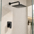 Kit de ducha negro mate con regadera cuadrada de 20 cm, tubo redondo y monocontrol cuadrado instalado en baño claro.